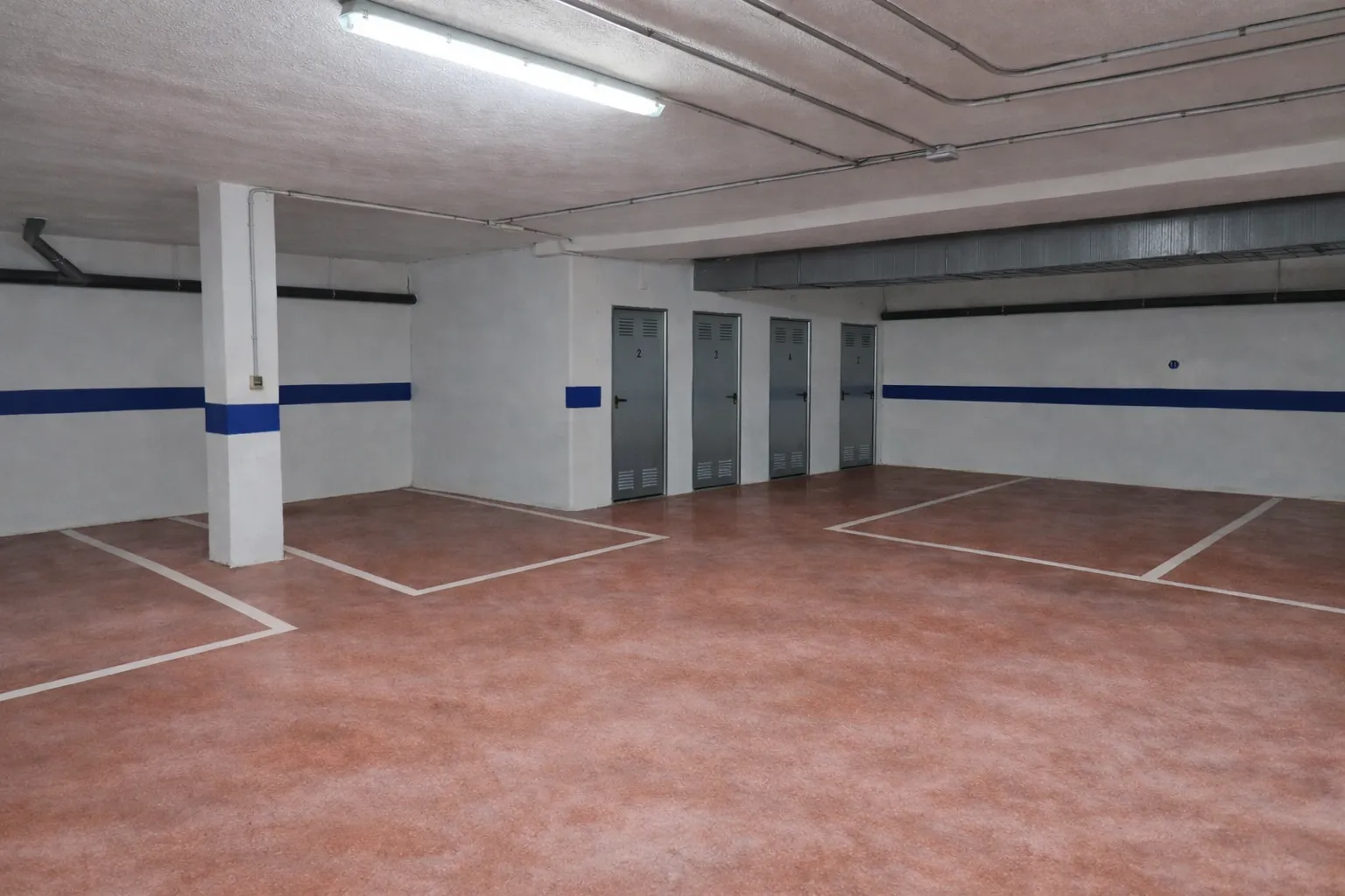 Fila de plazas de garaje con los pilares señalizados